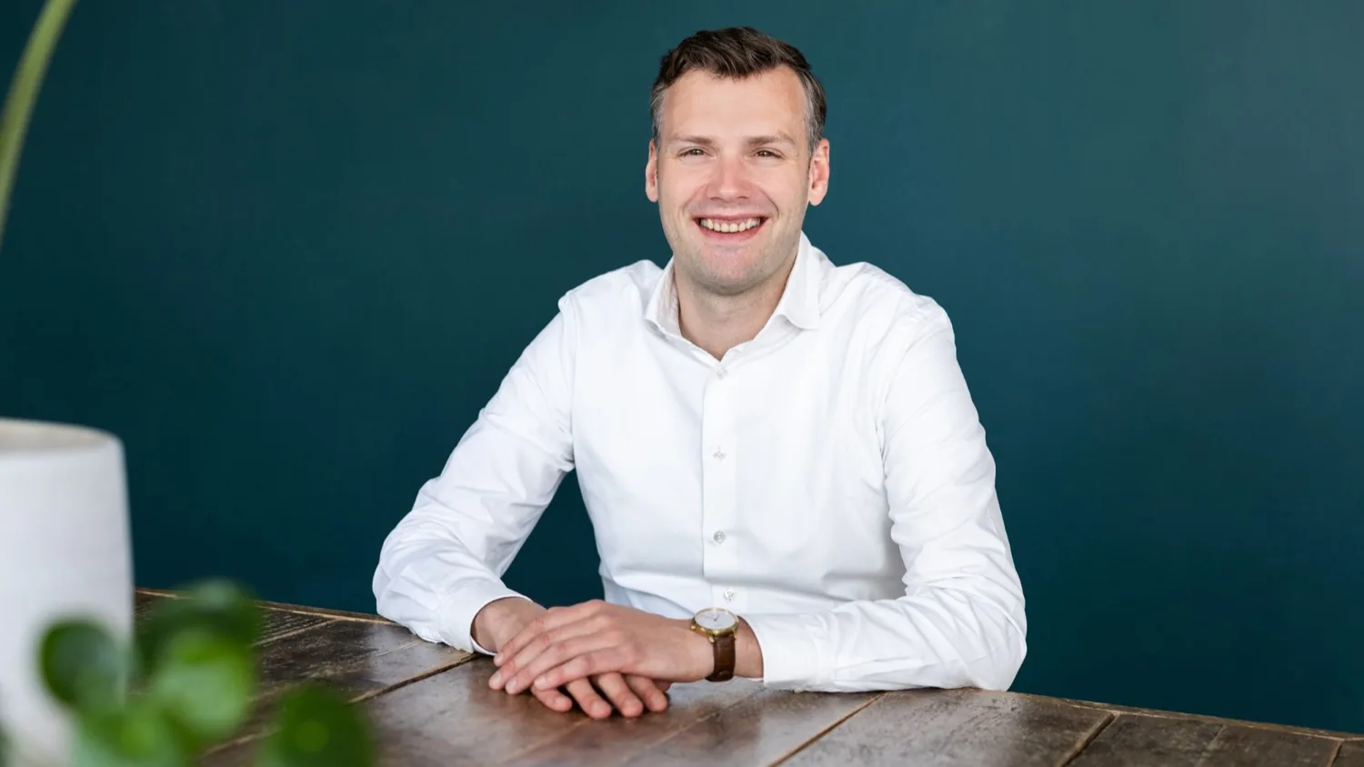 Mathijs Pluimers, lachend voor een groene wand